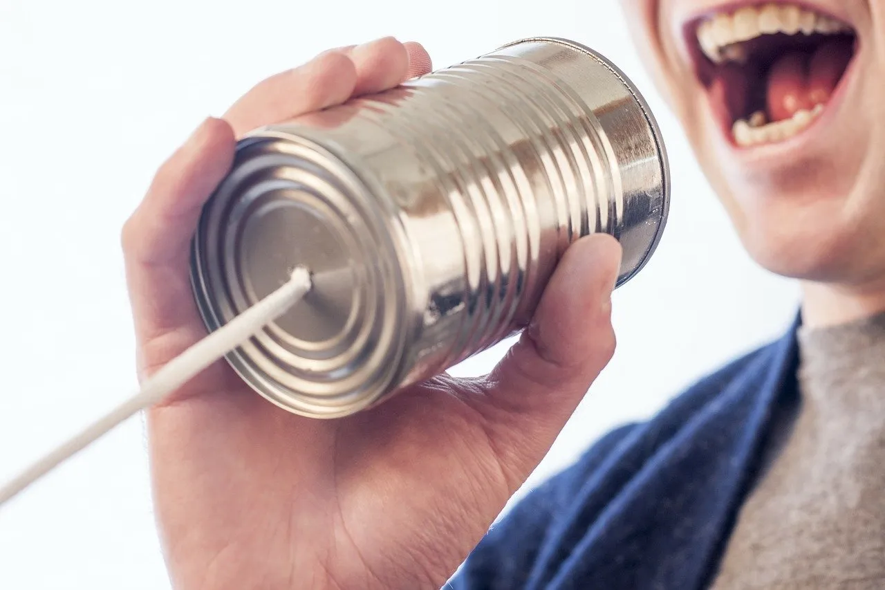 Due vecchi telefoni a barattolo che simboleggiano la differenza tra relazione e comunicazione